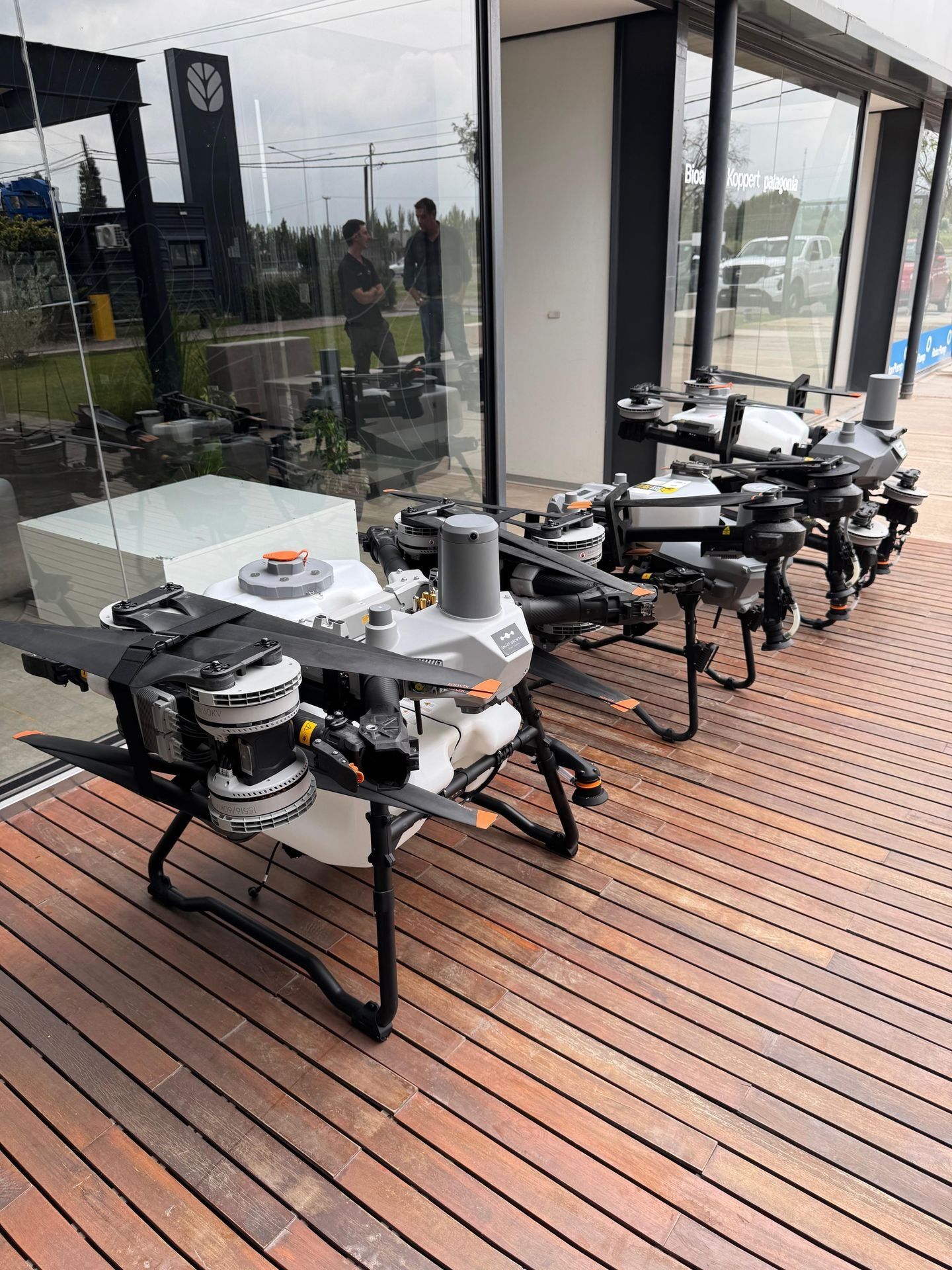 Drones agrícolas DJI Agras en exhibición sobre un deck de madera